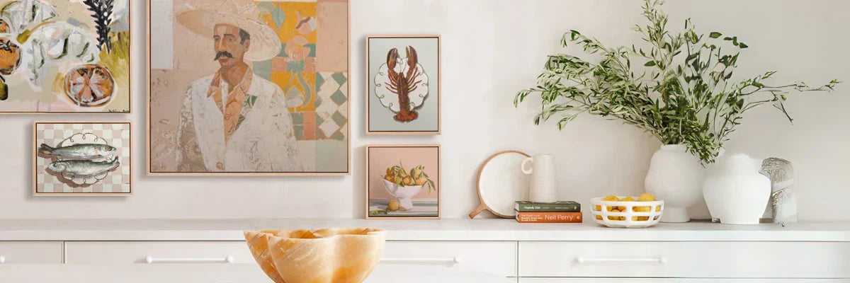 Stylish gallery wall art arrangement featuring contemporary framed prints in soft tones above a modern console table.