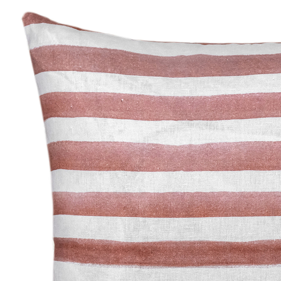 The Rumi Striped Terracotta Linen Cushion With Feather Insert (50x50cm) by Urban Road features hand-painted, uneven reddish-brown stripes on white—ideal for adding a modern boho touch to your decor.