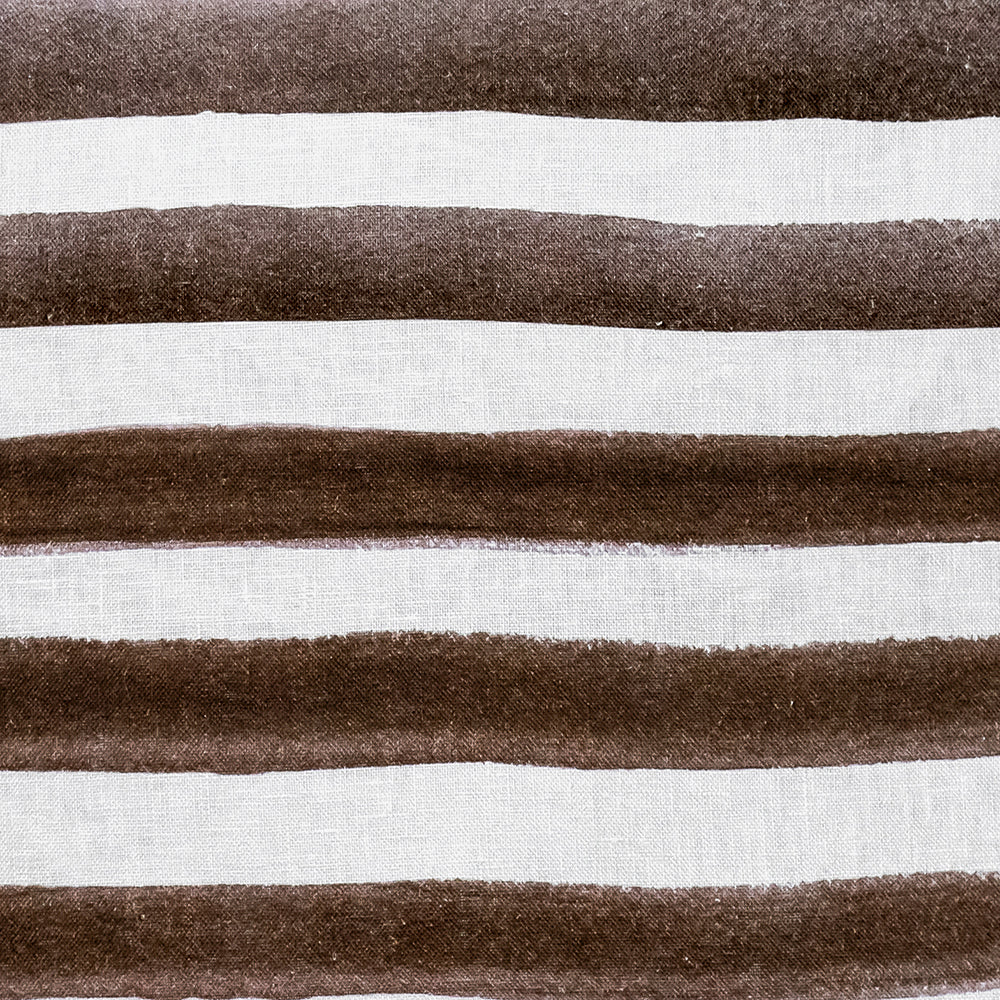 The Rumi Striped Chocolate Linen Cushion by Urban Road features horizontal brown and white stripes with a hand-painted effect, curved edges, and measures 50x50cm—a stylish accent for your home decor.