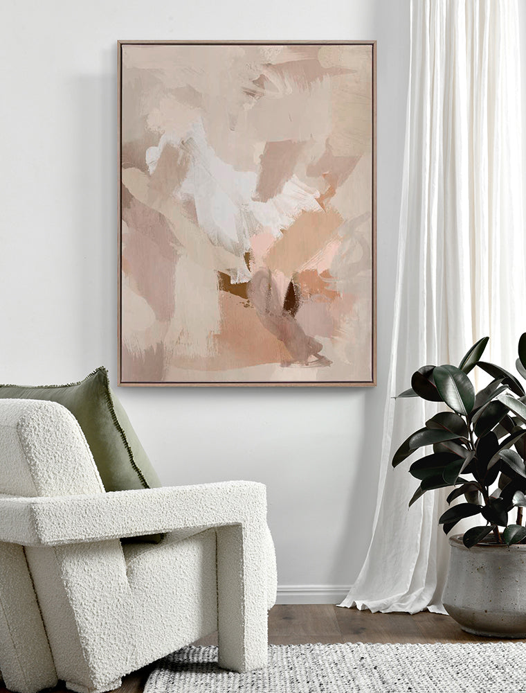 A cozy modern living room with a white textured armchair, green pillow, and Urban Road’s 'Untroubled' Oak Box Frame Canvas (90x120), featuring soft beige and blush tones on the wall, plus a potted plant by sheer white curtains.