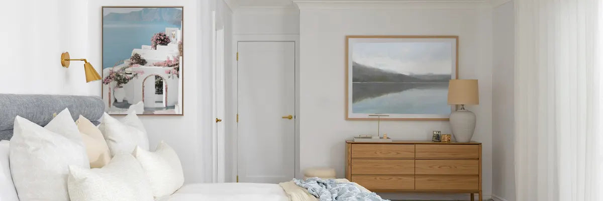 Relaxing Hamptons-style bedroom featuring serene coastal-themed artwork complemented by crisp, neutral decor and furnishings.