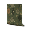 Lush dark green wallpaper with warm ochre and olive vases, scattered yellow florals, and curling black stems, from the Shatha collection with Urban Road.