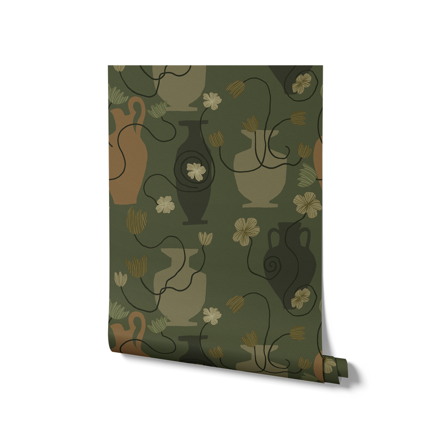 Lush dark green wallpaper with warm ochre and olive vases, scattered yellow florals, and curling black stems, from the Shatha collection with Urban Road.