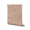 Soft pink wallpaper with cream-toned palm tree silhouettes and abstract tile-like brush strokes, from the Shatha collection with Urban Road.