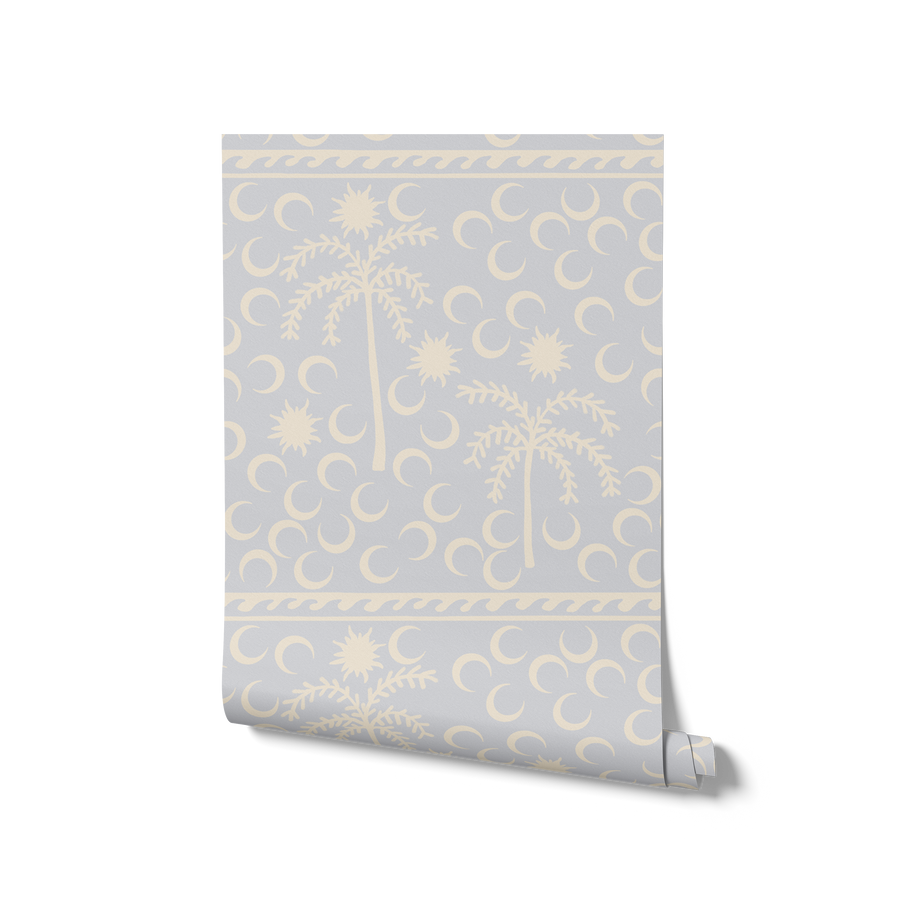 Playful sky blue wallpaper with cream palm trees and crescent moon motifs, bordered with a woven stripe detail, from the Shatha collection with Urban Road.