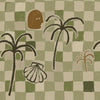 Warm brown wallpaper with golden ochre checkers, bold palm silhouettes, a soft face icon, and a white seashell drawing, from the Shatha collection with Urban Road.
