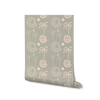 Mint green wallpaper with hand-drawn palm trees, swirling sunburst motifs, and crescent moons in pale cream, from the Shatha collection with Urban Road.