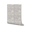 Soft sky blue wallpaper with cream-toned tropical illustrations of palms, moons, and spiral suns, from the Shatha collection with Urban Road.