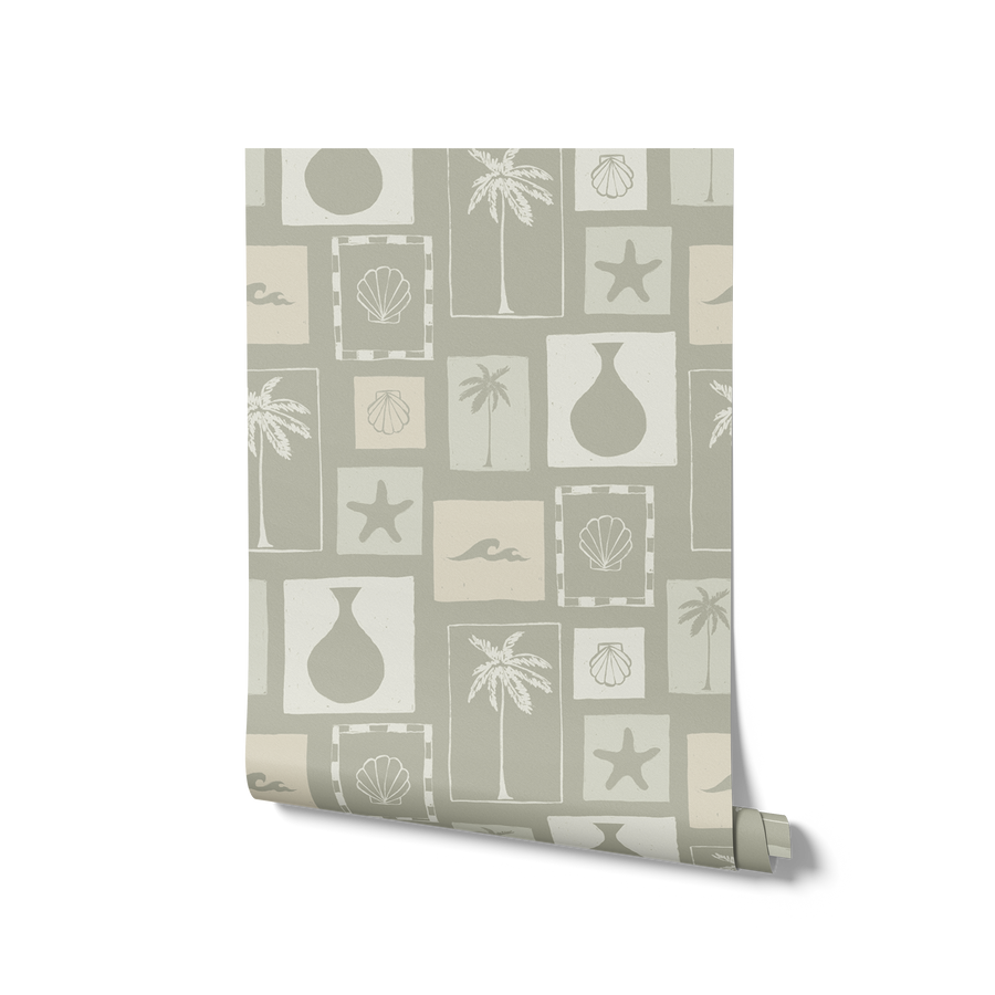 Soft sage wallpaper with cream-toned framed tropical imagery—palm silhouettes, shells, and abstract coastal elements, from the Shatha collection with Urban Road.