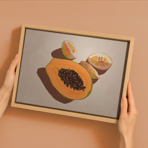 A person holds Urban Road’s "Oh my Papaya!"—a 22.5x30" landscape oak box frame canvas featuring halved papaya and melon art on a light backdrop, ideal for refreshing your summer home decor.