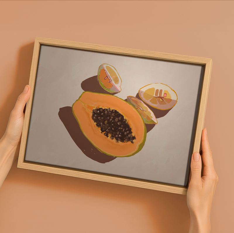 A person holds Urban Road’s "Oh my Papaya!"—a 22.5x30" landscape oak box frame canvas featuring halved papaya and melon art on a light backdrop, ideal for refreshing your summer home decor.