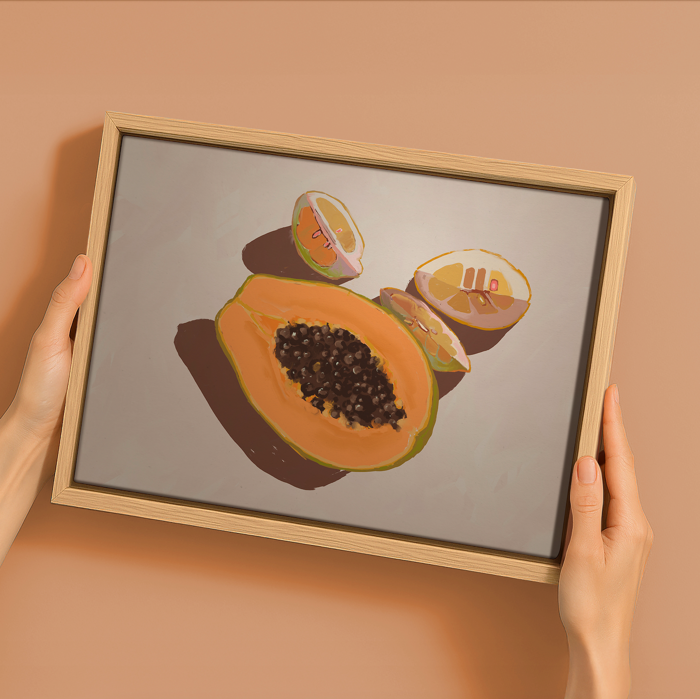 A person holds Urban Roadâ€™s "Oh my Papaya!"â€”a 22.5x30" landscape oak box frame canvas featuring halved papaya and melon art on a light backdrop, ideal for refreshing your summer home decor.