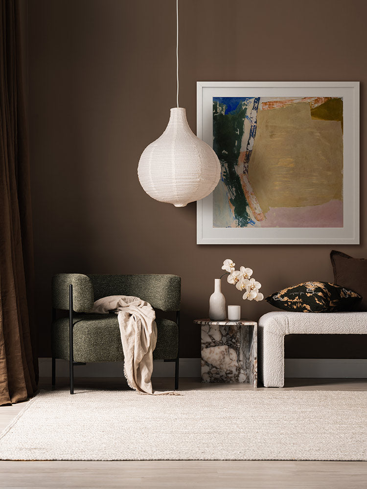Desert Blush II abstract wall art print styled with neutral seating and decor, a checkered rug, and a dark brown wall.