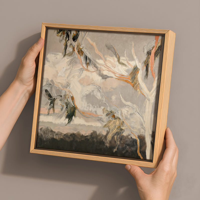 Two hands hold Urban Road's "Evening Gum Leaves" 30x30 oak box frame canvas, featuring abstract gray, white, orange, and green brushstrokes—perfect for modern interiors and inspired by Australian landscapes.
