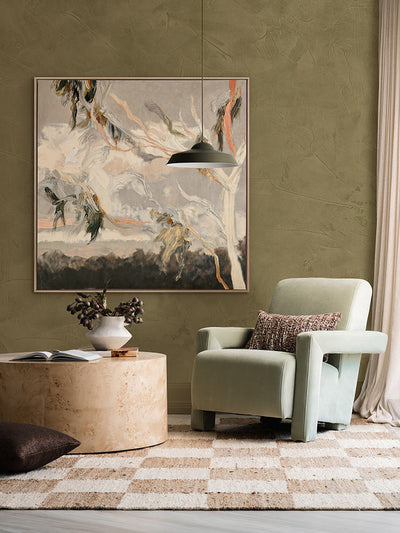 Evening Gum Leaves wall art print hangs in a sage-toned room with a soft armchair, warm wooden accents and checkered rug.
