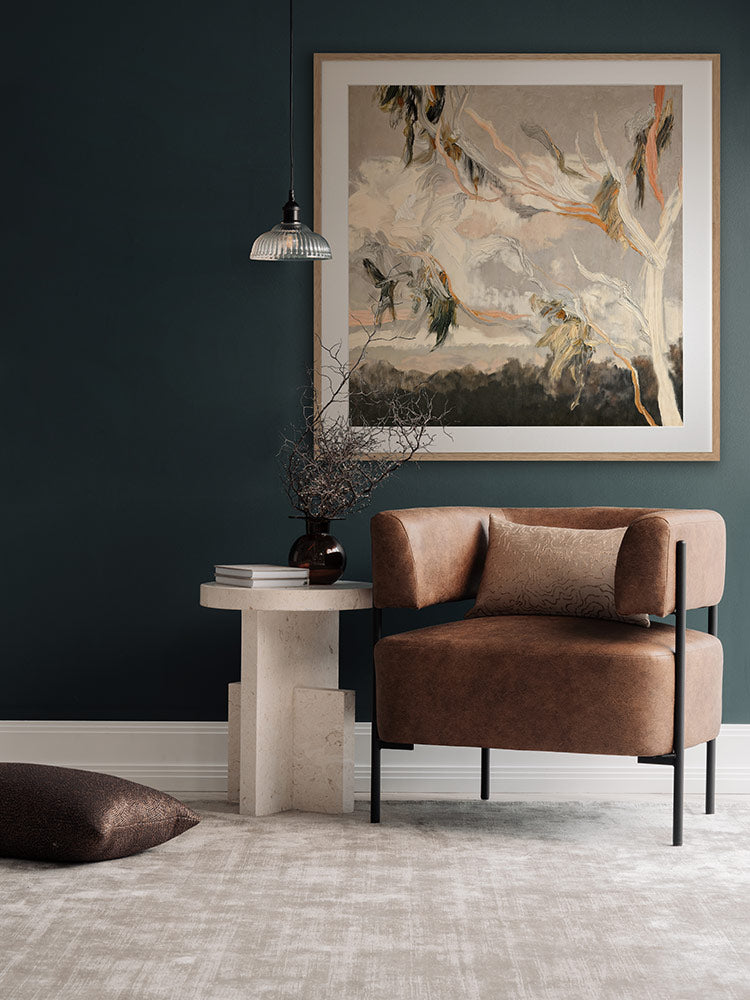 Evening Gum Leaves wall art print hangs in a sage-toned room with a soft armchair, warm wooden accents and checkered rug.