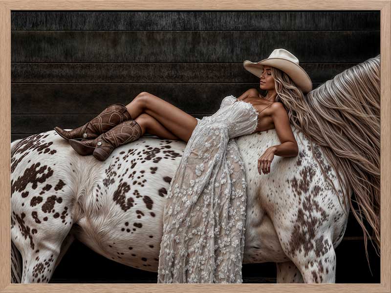 Glamorous photographic horse wall art featuring a woman in a cowboy hat and boots relaxing on a horse in earthy tones.