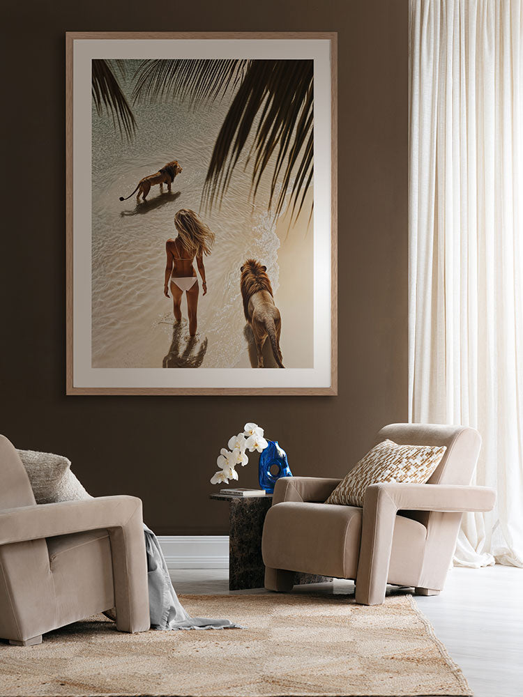 Lioness artwork in a neutral living room with green armchair, white love seat, and dark red-brown curtains and cushions.