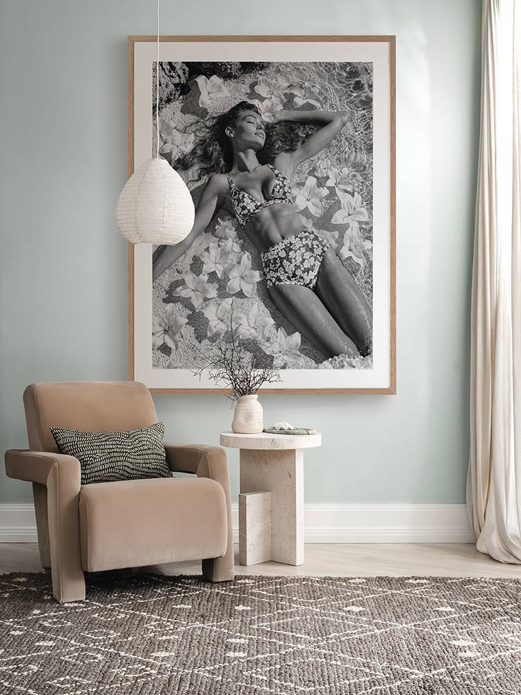 What Dreams Are Made Of black-and-white print above a white armchair side table with grey walls and soft, muted styling.