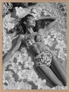 Monochrome photographic artwork of a serene woman lounging amid flowers in water, giving all the luxurious vibes.