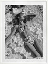 Monochrome photographic artwork of a serene woman lounging amid flowers in water, giving all the luxurious vibes.
