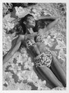 Monochrome photographic artwork of a serene woman lounging amid flowers in water, giving all the luxurious vibes.