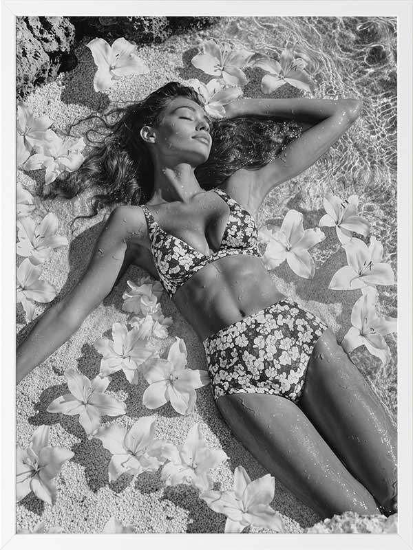 Monochrome photographic artwork of a serene woman lounging amid flowers in water, giving all the luxurious vibes.