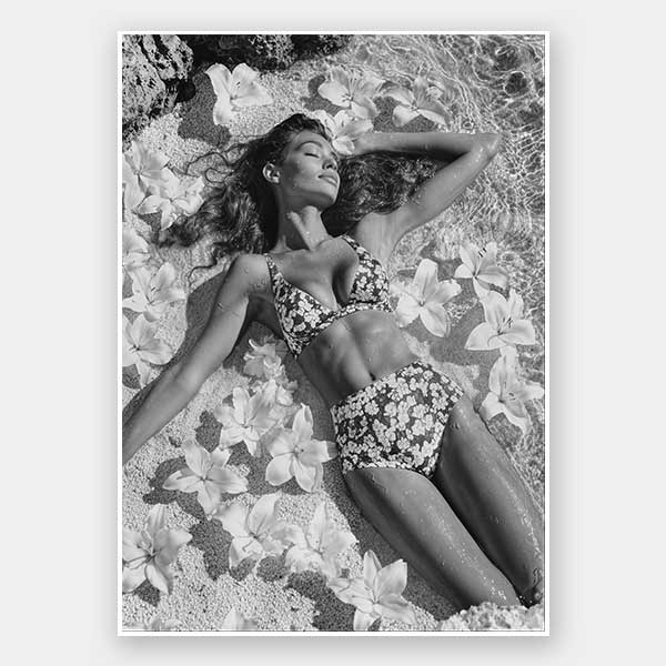 Monochrome photographic artwork of a serene woman lounging amid flowers in water, giving all the luxurious vibes.