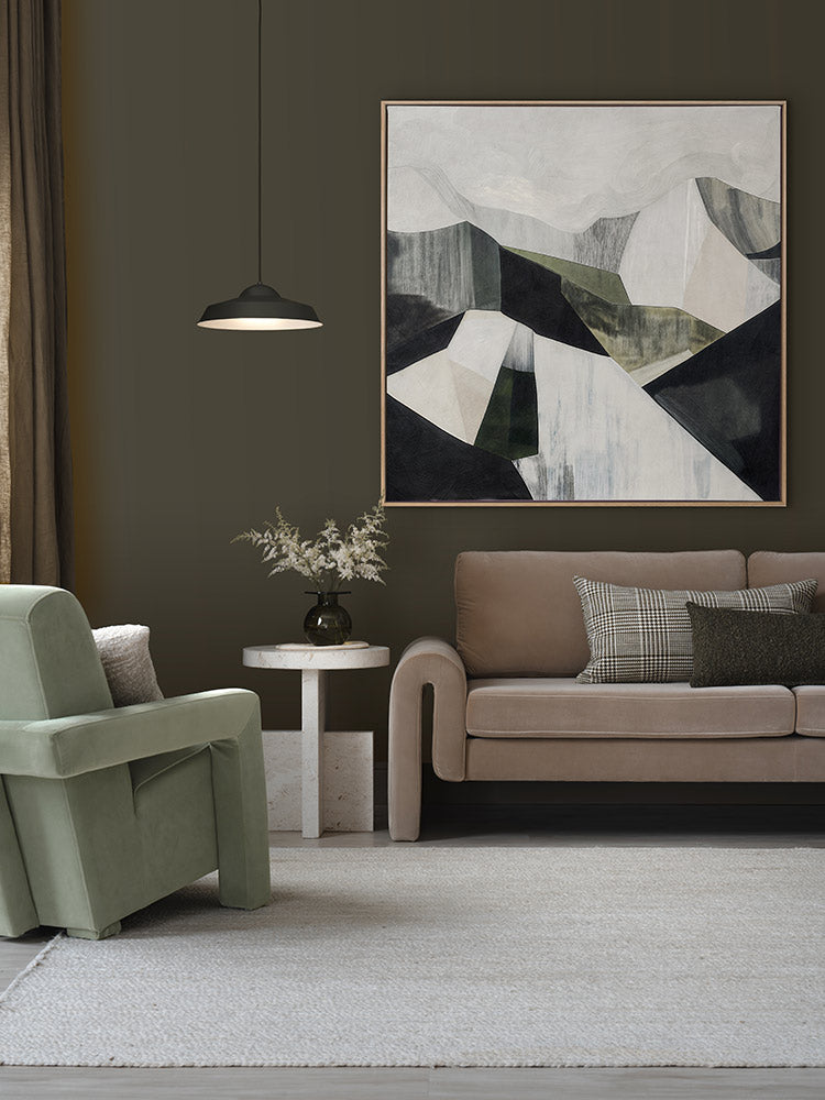 Geometric Landscape II abstract artwork above a tan sofa and green armchair, styled with dried florals and neutral decor.