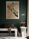 Warm Memories I abstract art above a sage green couch, patterned armchair, white rug and other neutral decor.