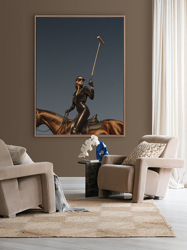 She’s a Polo Player portrait art hanging in a modern lounge with beige armchairs, white curtains and a sculptural side table.