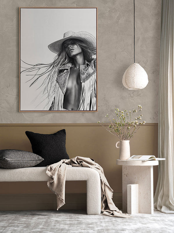 Framed Wild Spirit black-and-white portrait art in a modern room with neutral decor, dark cushions, and minimal styling.