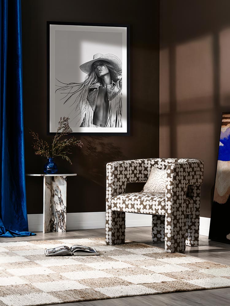 Framed Wild Spirit black-and-white portrait art in a modern room with neutral decor, dark cushions, and minimal styling.