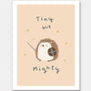 A tiny hedgehog holding a little sword and shield with scattered stars and the phrase “tiny but mighty” in warm neutral browns, from the Little Tails Collection by Urban Road.
