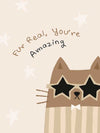 A friendly cat wearing star-shaped sunglasses with the hand-lettered message “fur real, you’re amazing” and small stars, in soft neutral browns, from the Little Tails Collection by Urban Road.
