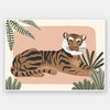 A relaxed tiger lounges among leafy jungle plants in soft pink and brown tones, from the Little Tails Collection by Urban Road.