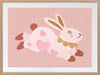 A leaping pink bunny sprinkled with heart patches on a textured blush ground, from the Little Tails collection by Urban Road.