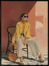 A seated woman in patterned pants and a yellow blouse leans casually against a terracotta wall. From the Lounging Ladies II collection by Urban Road.