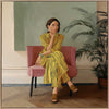 Portrait of a woman in yellow stripes sitting offline in a muted room setting, from the Lounging Ladies II collection by Urban Road.