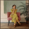 Portrait of a woman in yellow stripes sitting offline in a muted room setting, from the Lounging Ladies II collection by Urban Road.