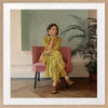 Portrait of a woman in yellow stripes sitting offline in a muted room setting, from the Lounging Ladies II collection by Urban Road.