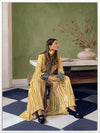 Woman in yellow-striped fashion sits poised against a green wall and patterned flooring in a moment of composed stillness, from the Lounging Ladies II collection by Urban Road.