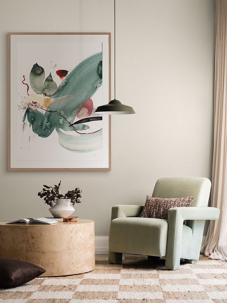 Hidden Cove 3 abstract art print styled with a green armchair with florals, patterned rug, curtains and a striped cushion.