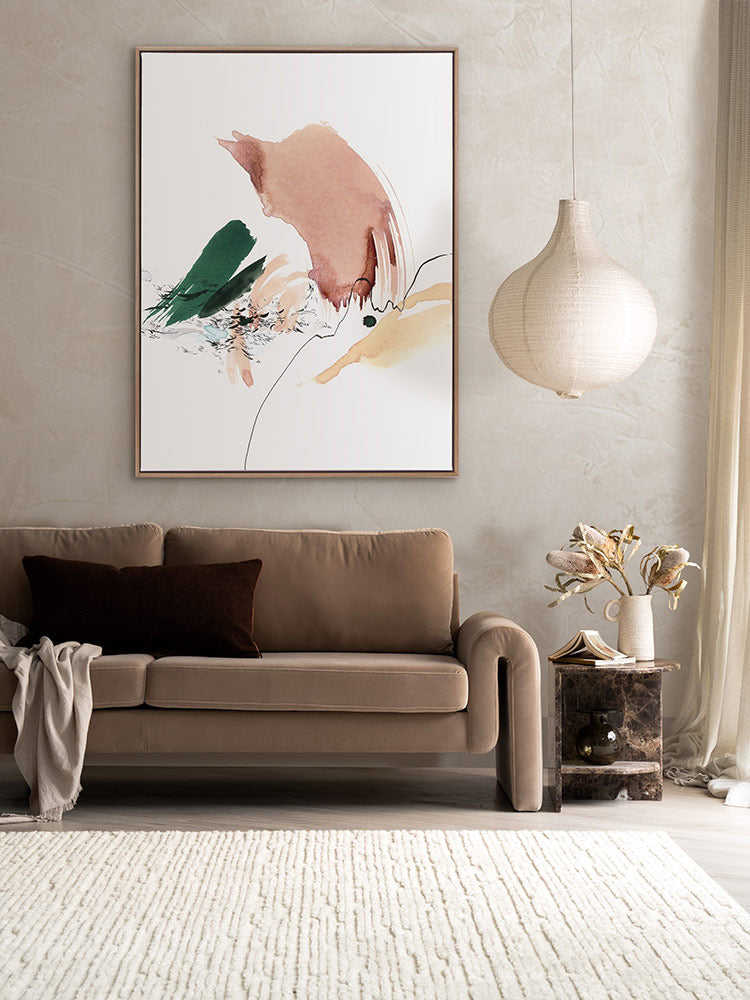 Setting Horizon styled in a neutral, soft living area with a beige sofa, brown side table, white rug and a dark cushion.