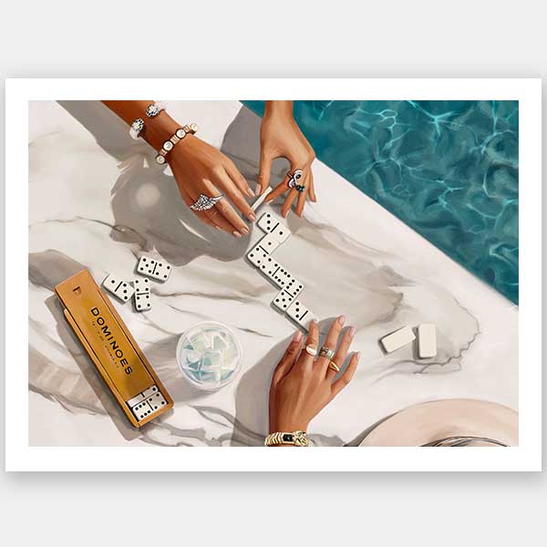 Two people with manicured hands and jewelry play dominoes on marble by a poolside, with a gold domino box and drink nearby in this sunlit scene—featured in the Poolside Dominoes Unframed Art Print by Shaynna Blaze x Urban Road.