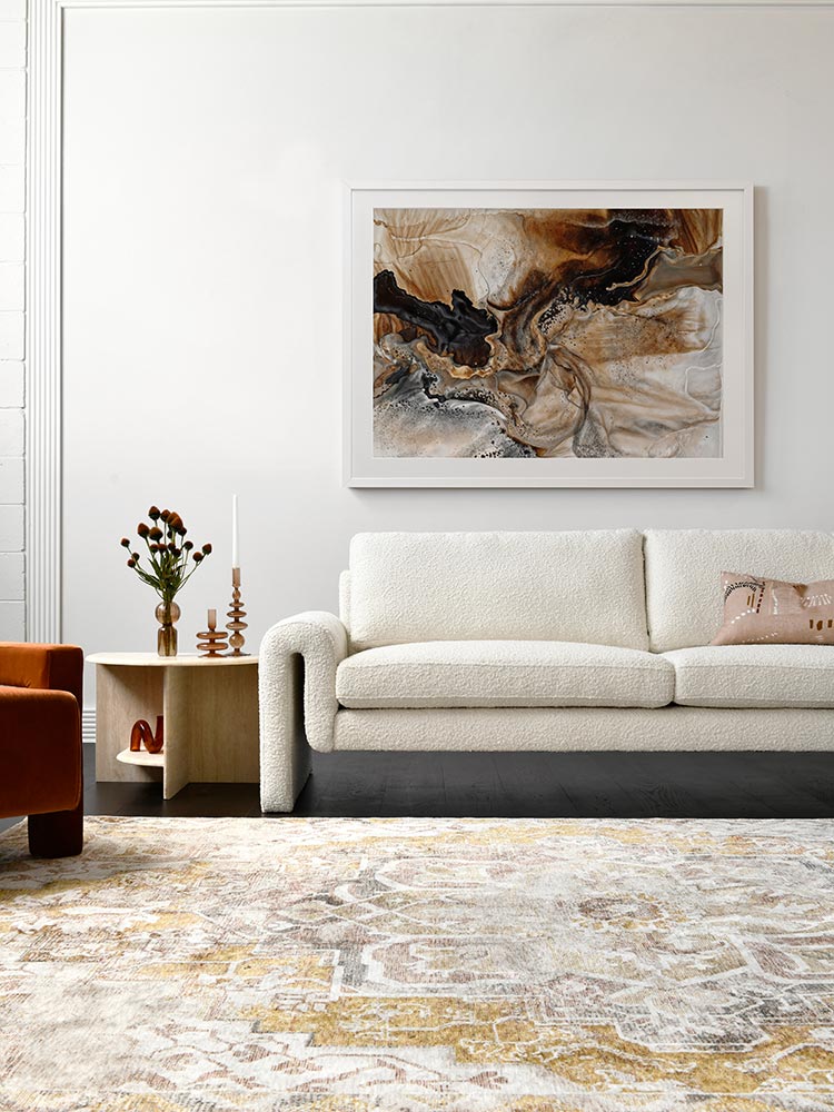 A framed Terrain Tides II art print displayed in a neutral-toned living space. The abstract artwork features earthy browns, black, and beige, complementing the warm, minimalist decor.