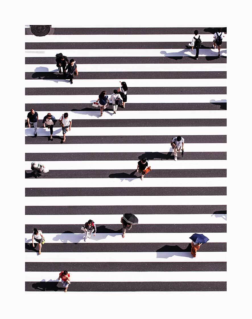 The Pedestrian Unframed Art Print by Urban Road captures an aerial view of people with bags or umbrellas crossing a bold zebra crossing, their shadows visible on the urban pavement.