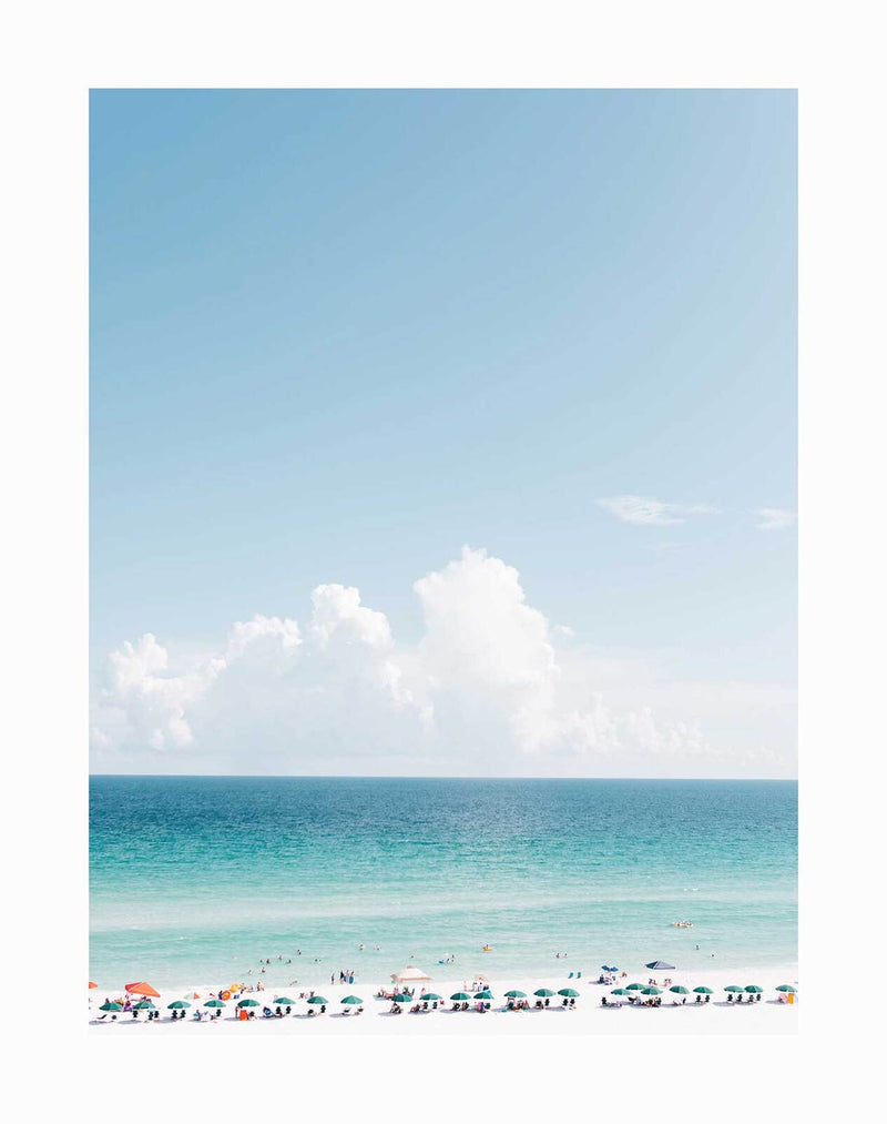 Vitamin Sea Unframed Art Print by Urban Road features a bright beach scene with colorful umbrellas, people relaxing on the sand, and swimmers in a turquoise ocean beneath white clouds and a clear blue sky.