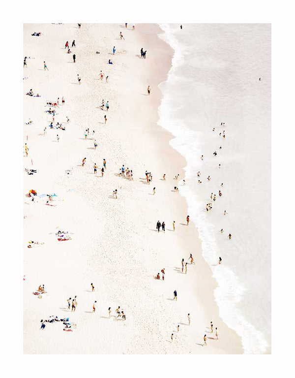 A bird's eye view of a lively sandy shore, captured in the Bleached Beach Unframed Art Print by Urban Road, shows people sunbathing and swimming as gentle waves complete this true summer scene.