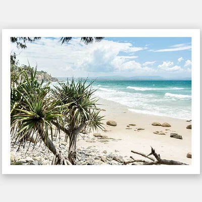 Bring a slice of paradise to your space with Urban Road’s “Welcome to Paradise” Unframed Art Print, featuring turquoise waves, white sand, rocks, and pandanus trees under a partly cloudy sky—the perfect striking accent for any room.